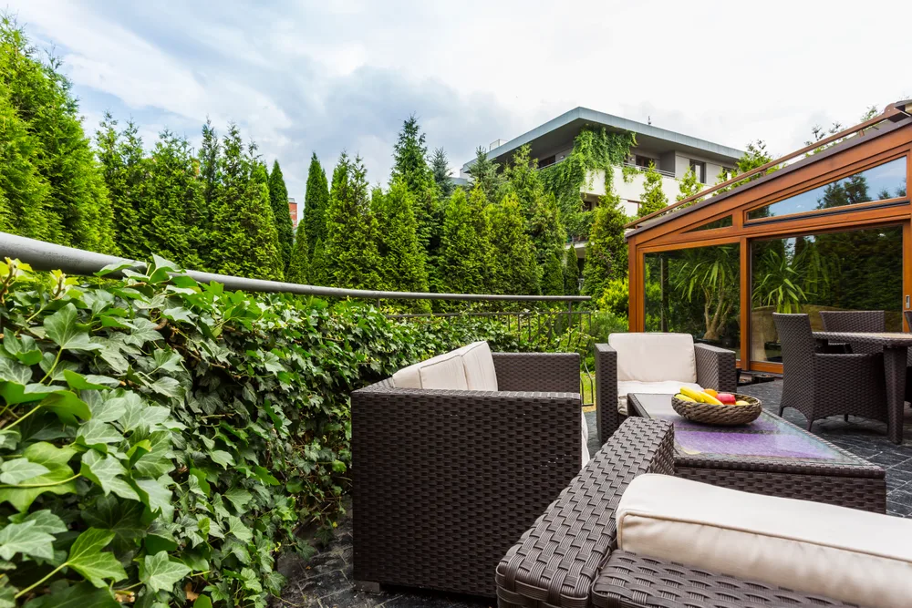 Terraza con sillones y mesa de café rodeada de vegetación