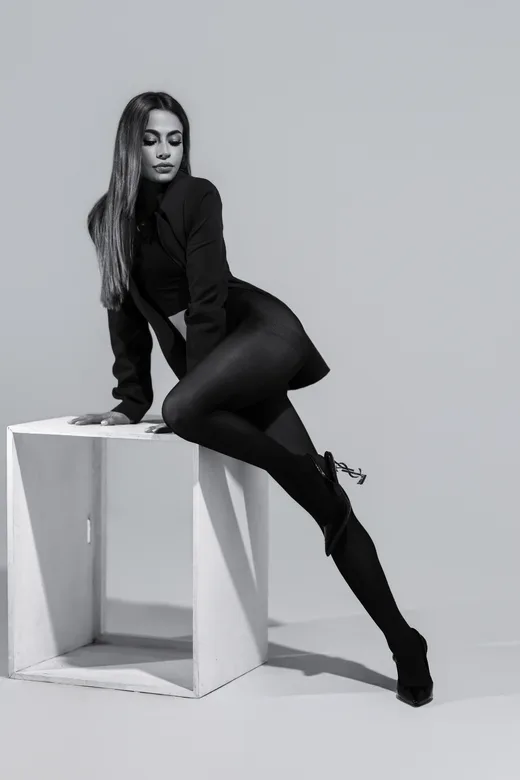 Fotografía en blanco y negro de una mujer sentada sobre un cubo